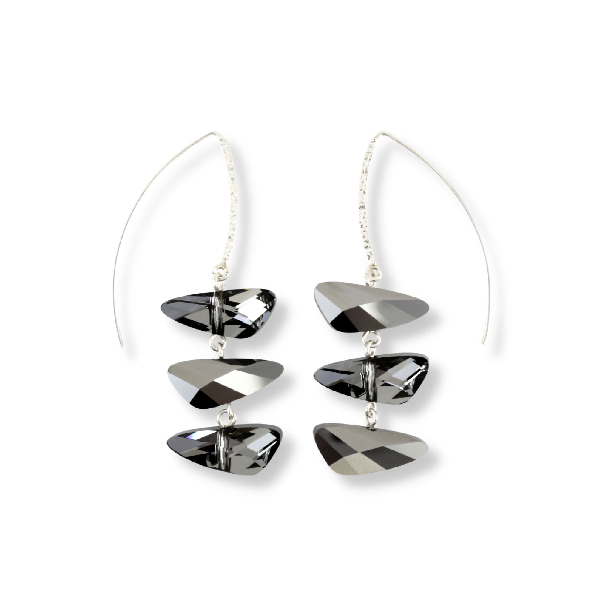 Wing shaped Swarovski crystal pendant earrings in a reflective dark grey color displayed on a long sterling silver marquise hook